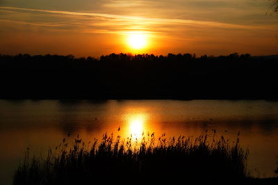 Scenic view of lake against sky during sunset