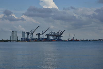 Commercial dock by sea against sky