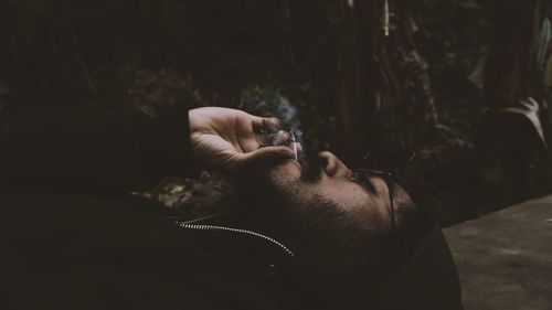  young man lying on floor while smoking