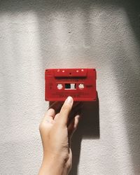 Hand holding a red phil collins cassette tape