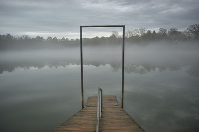 Pier over lake against sky