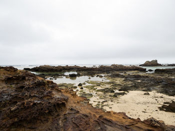 Rocks on beach against sky