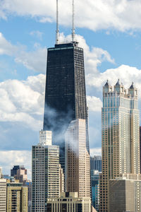 Low angle view of buildings against cloudy sky