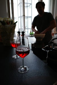 Wine in glasses on table with man in background