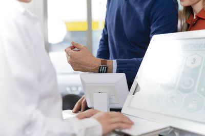 Male customer paying with smart watch at pharmacy checkout