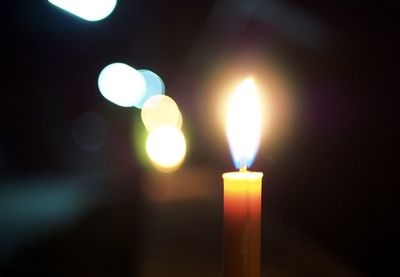 Close-up of lit candle in the dark