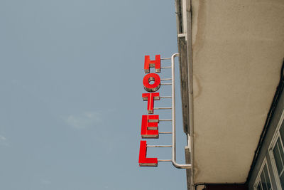 Low angle view of hotel sign against sky