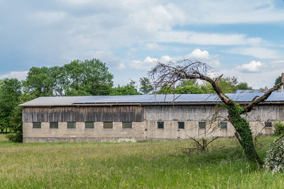 Old house on field against sky