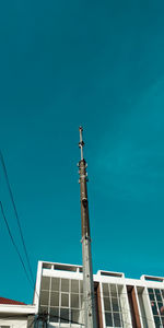 Low angle view of communications tower against clear blue sky