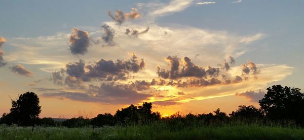 Scenic view of field against cloudy sky