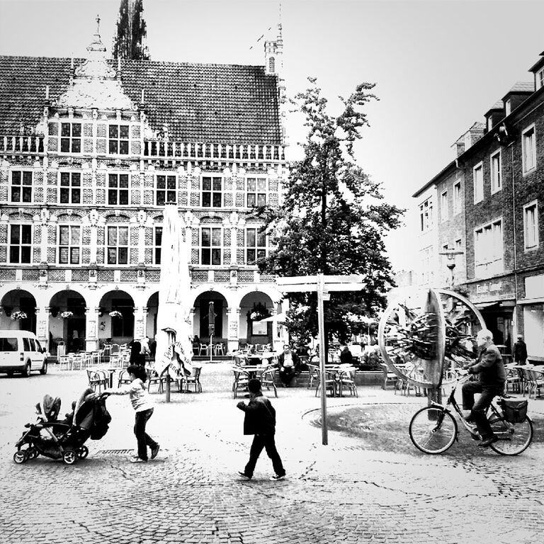 building exterior, architecture, built structure, bicycle, men, lifestyles, street, walking, full length, person, city, leisure activity, city life, land vehicle, transportation, cobblestone, large group of people, building, mode of transport