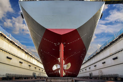 Ship moored at harbor against sky