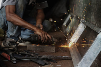 Low section of male worker grinding at workshop