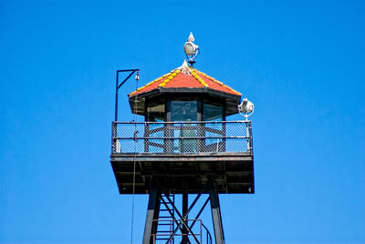 Low angle view of lookout tower against clear blue sky