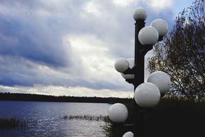White balloons on lake against sky