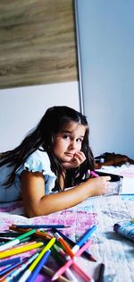 Portrait of a girl sitting on book at home