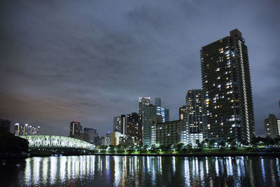 Illuminated buildings against sky at night