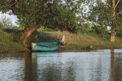 Boat in lake against trees in forest