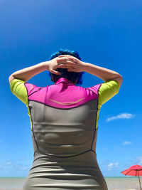 Low angle view of woman standing against pink blue sky