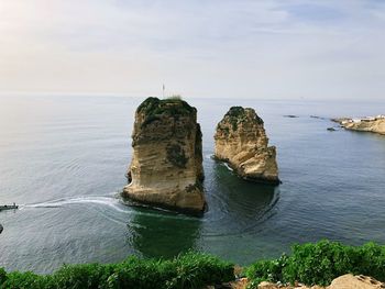 Rock formation in sea against sky