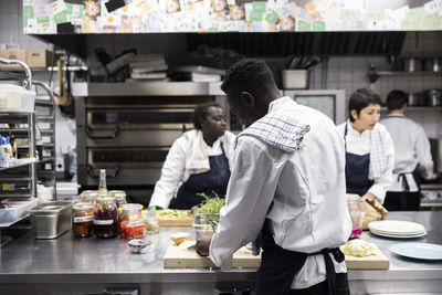 Multiracial chefs preparing food in kitchen of restaurant