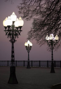 Low angle view of illuminated street light against sky