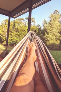 Low section of person relaxing on hammock