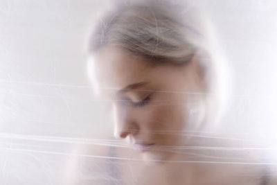 Close-up portrait of young woman over white background