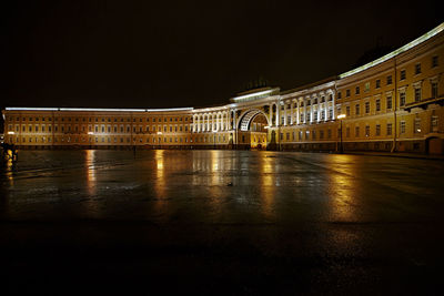 Illuminated bridge over river at night