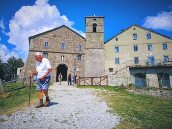 People standing outside house against building