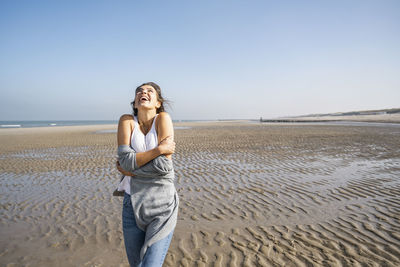 Man standing on beach against clear sky