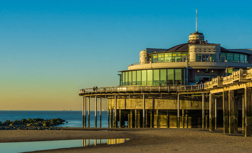 Built structure on beach against clear sky