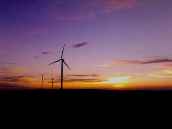 Silhouette of wind turbines at sunset