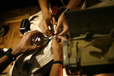 Cropped hands of people working on fabric