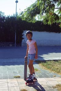 Portrait of smiling boy standing on footpath