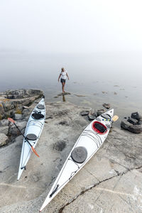 Woman resting near canoes, sweden