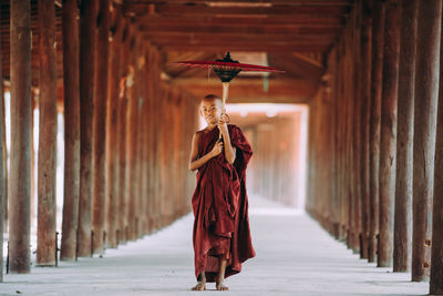 Rear view of man walking in temple outside building