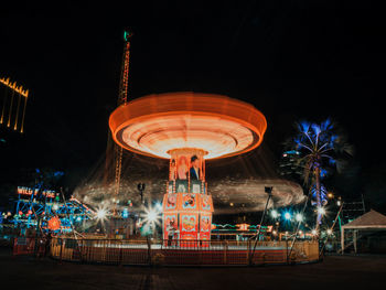 Low angle view of illuminated ferris wheel at night