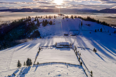 Scenic view of snow covered field against sky