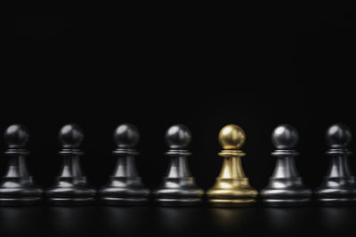 Close-up of chess pieces against black background