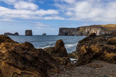 Rock formation on beach against sky