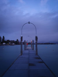 Pier over sea against sky at dusk