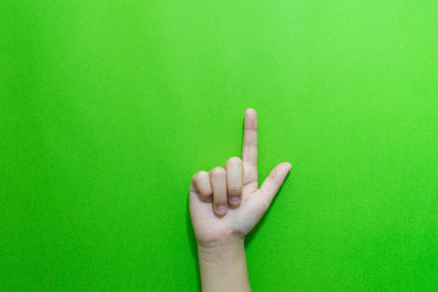 Close-up of hand over green background