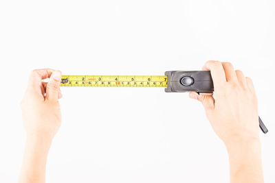 Midsection of person holding camera against white background