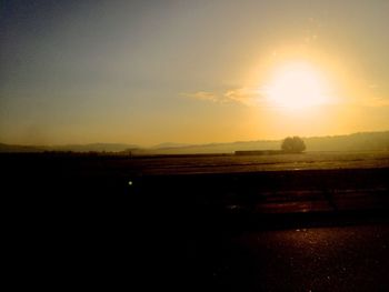 Scenic view of silhouette field against sky during sunset