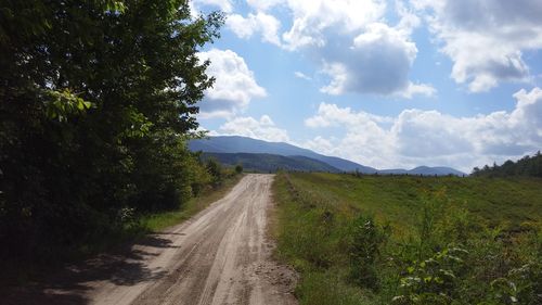 Road amidst trees against sky