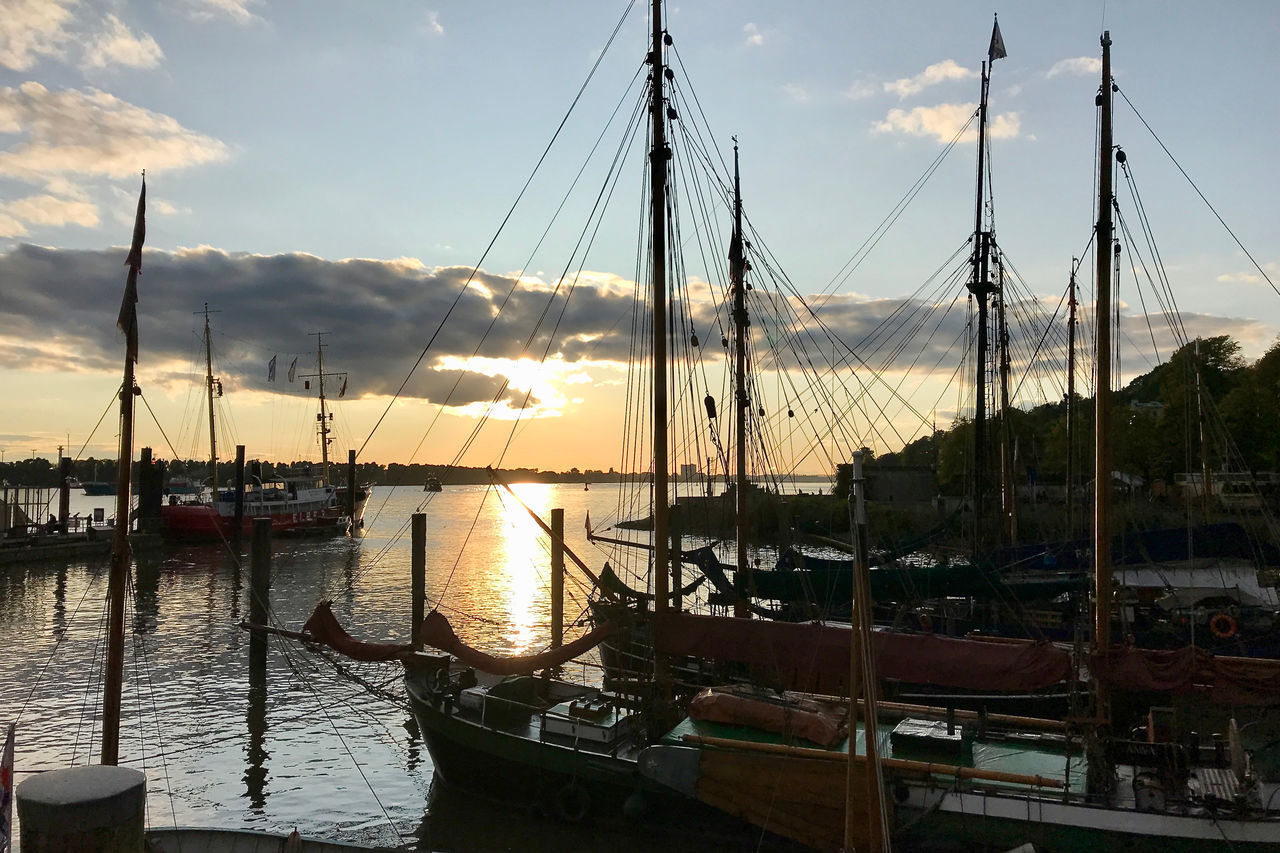 SAILBOATS MOORED AT HARBOR AGAINST SKY