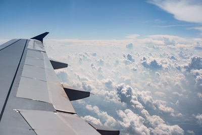 Airplane flying over clouds against sky