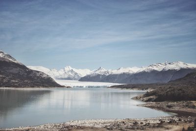 Scenic view of lake and snowcapped mountains against sky