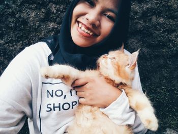Portrait of smiling young woman with cat